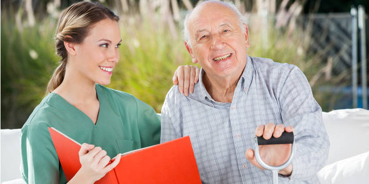 Smiling Senior Sitting Outside with his Caregiver