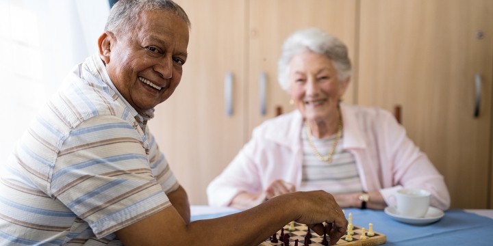 Happy seniors playing chess