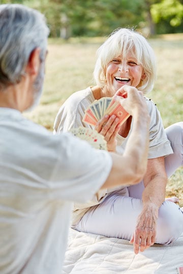 Elderly couple playing cards in a park