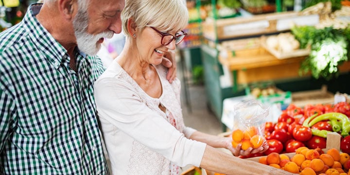 Senior couple shopping for produce together at the grocery store