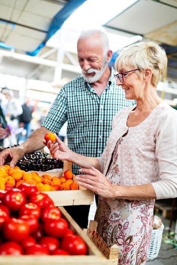 Senior couple shopping for fresh produce at a farmers market