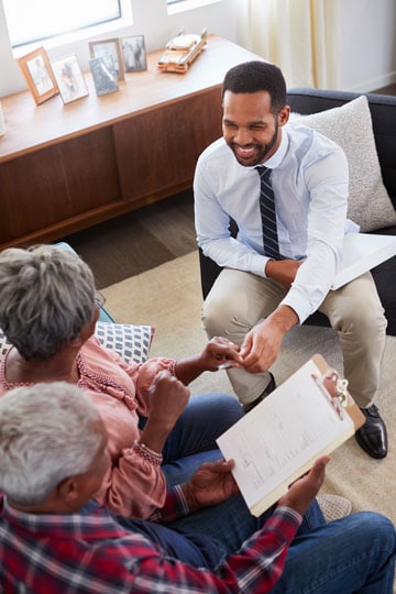 Smiling tax advisor consulting with elderly couple