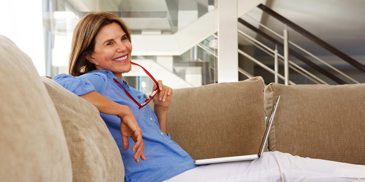 Woman sitting on a couch with her laptop computer open