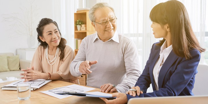 Elderly couple in a meeting with a professional woman in a brightly lit living room