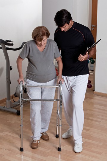 With the guidance of a skilled physiotherapist, an elderly woman learns how to use a walker to enhance her balance and mobility.