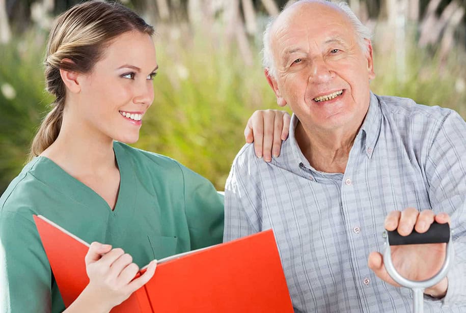 Smiling Senior Sitting Outside with his Caregiver