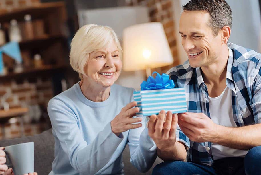 Happy grandparents opening gift from grandchild