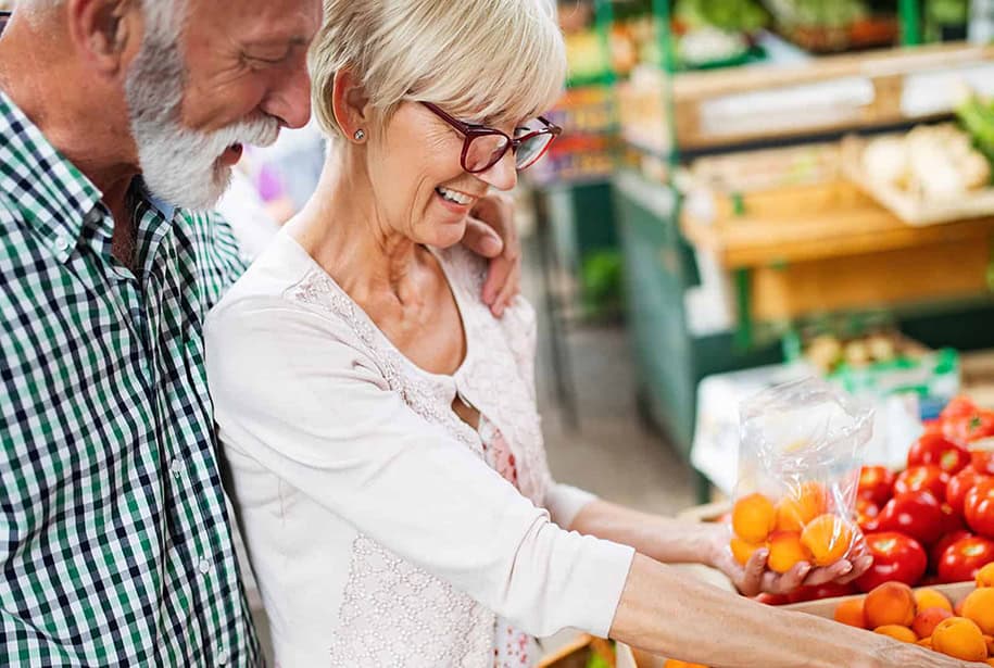 Senior couple shopping for produce together at the grocery store