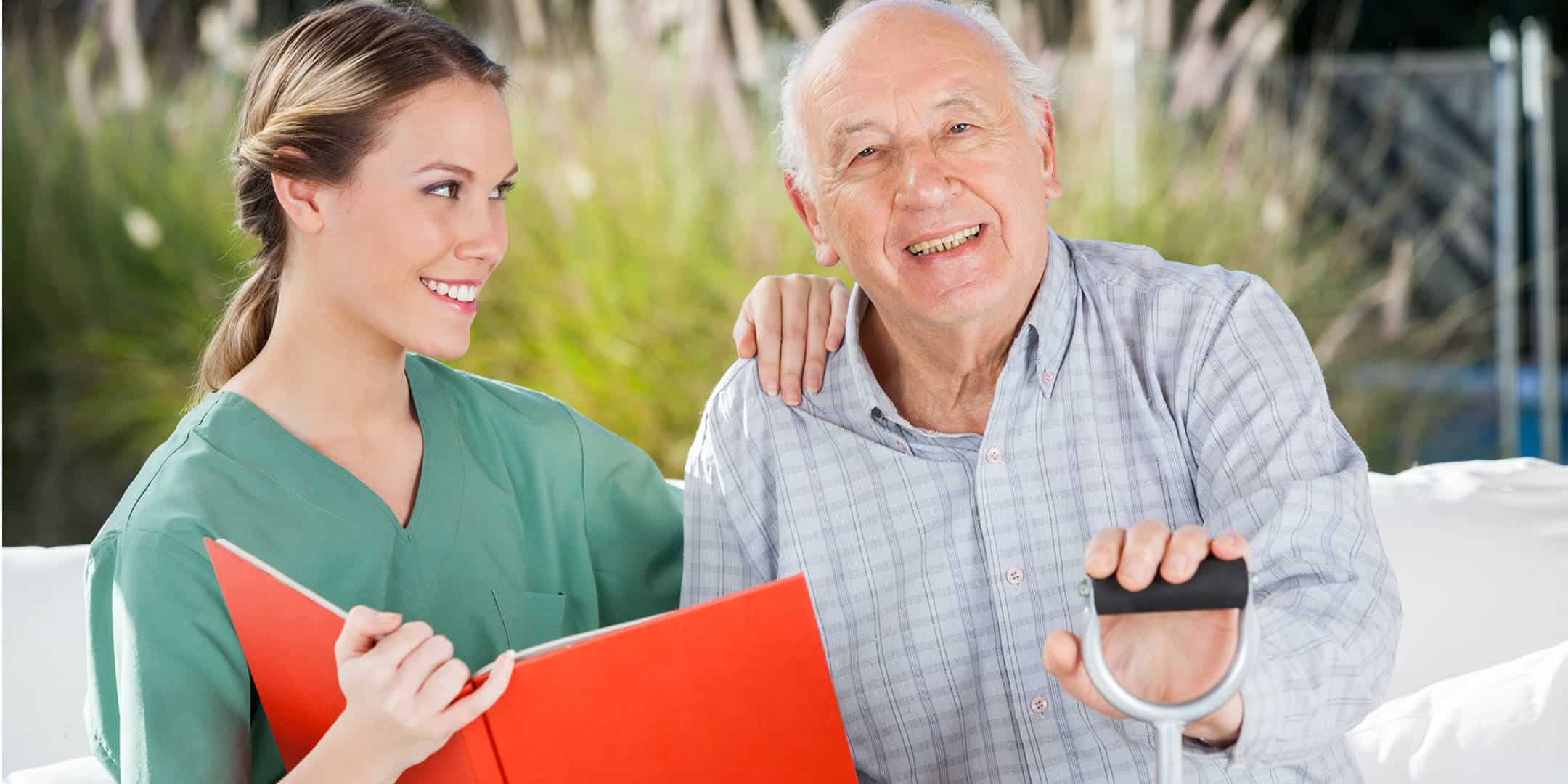 Smiling Senior Sitting Outside with his Caregiver