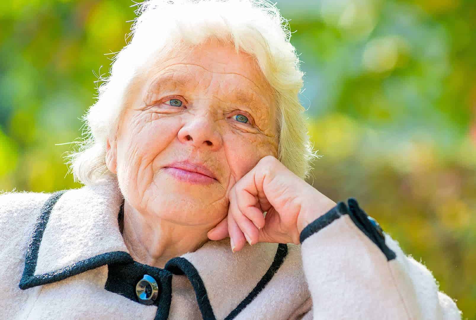 Senior women rest her head on her hand looking up