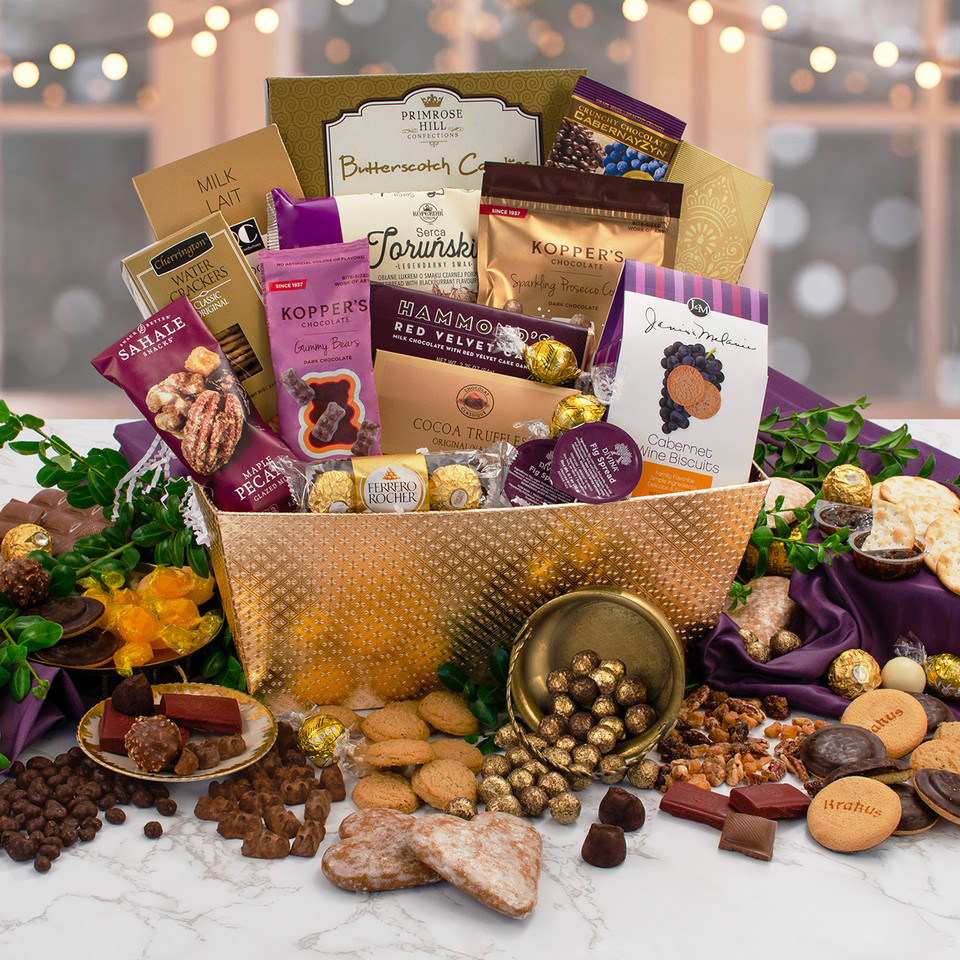 Gourmet gift baskets with assorted chocolates, cookies, and nuts on a table.